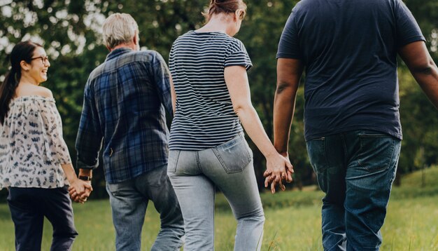 Verschiedene Leute, die Hände anhalten und in den Park laufen