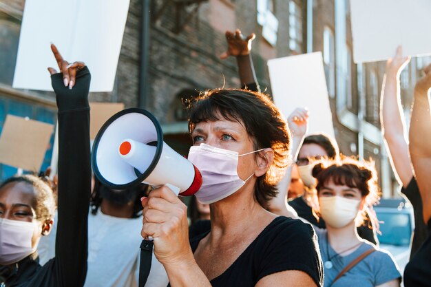 Verschiedene Menschen, die eine Maske tragen, protestieren während der COVID-19-Pandemie