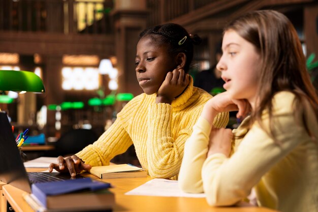 Verschiedene Preteen-Studenten in der Bibliothek beteiligen sich an einem E-Learning-Seminar