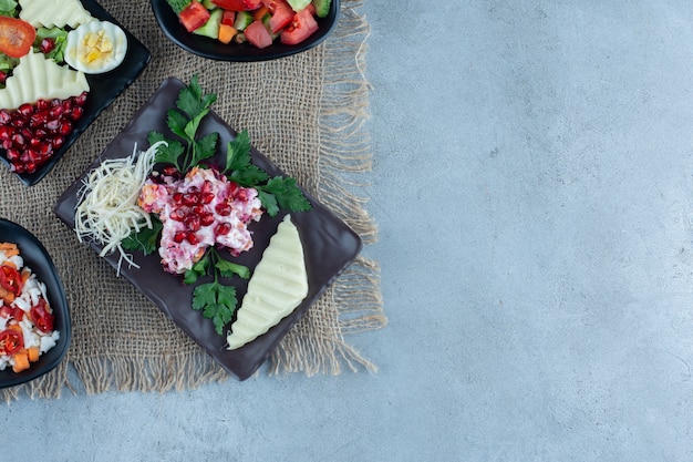 Verschiedene Salate auf Platten auf Marmor.