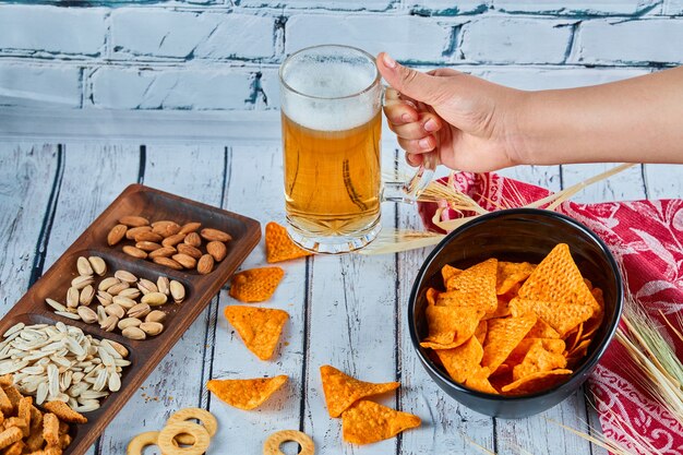 Verschiedene Snacks, Pommes und Bier auf blauem Tisch. Tisch für eine Gruppe von Freunden.