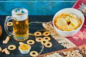 Kostenloses Foto verschiedene snacks, pommes und ein glas bier auf einem dunklen tisch.