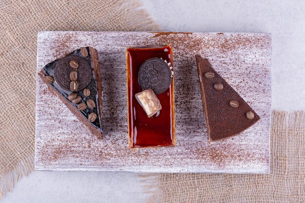 Verschiedene süße Kuchen auf Holzbrett mit Sackleinen. Foto in hoher Qualität