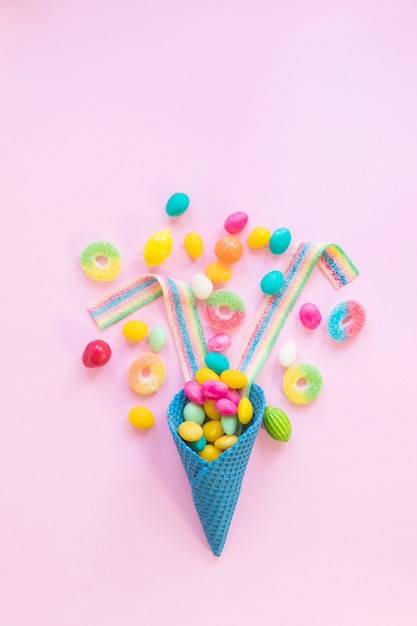 Verschiedene Süßigkeiten auf rosa Hintergrund