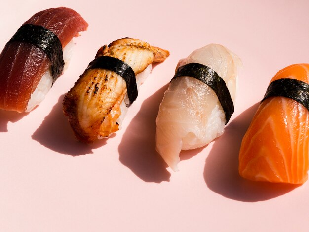 Verschiedene Sushi auf rosafarbenem Hintergrund
