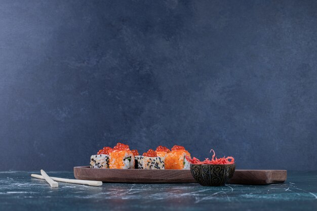 Verschiedene Sushi-Rollen mit rotem Kaviar und Essstäbchen.