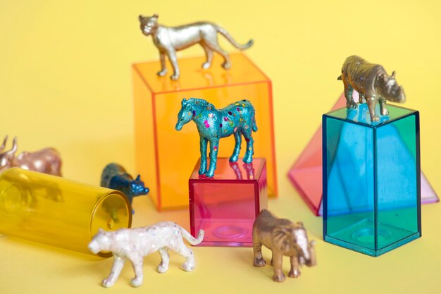 Verschiedene Tierspielzeugfiguren mit Kästen und in einem bunten Hintergrund