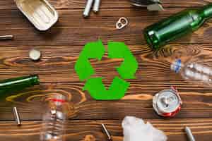 Kostenloses Foto verschiedene wiederverwendbare abfälle rund um das recycling-symbol