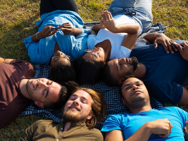 Verschiedenes Team von Freunden, die im Park sich entspannen