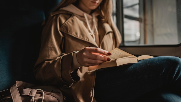 Verschwommene Frau, die ein Buch innerhalb eines Zuges liest