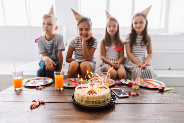 Verschwommene Kinder in der Nähe von Geburtstagskuchen