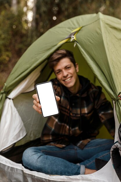 Verschwommener glücklicher Campingmann im Wald