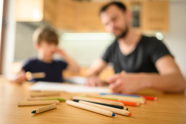 Kostenloses Foto verschwommener vater und sohn am tisch