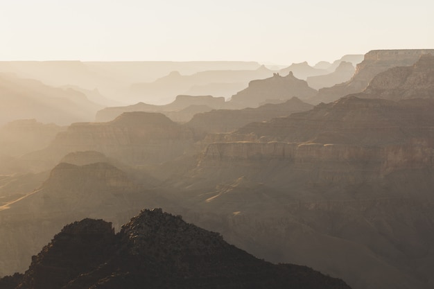 Verschwommenes Panorama eines Hügels mit dem Hintergrund der hohen Berge, die im Nebel bedeckt sind