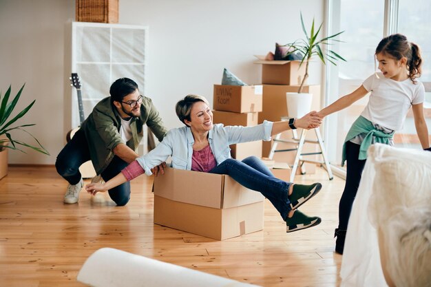 Verspielte Familie, die gemeinsam Spaß hat, während sie in ihr neues Haus einzieht