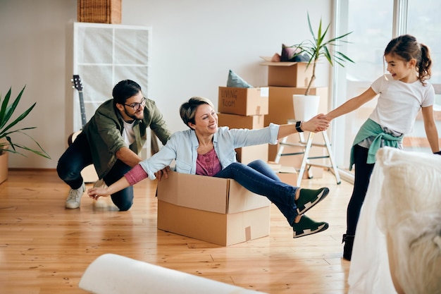 Verspielte Familie, die gemeinsam Spaß hat, während sie in ihr neues Haus einzieht