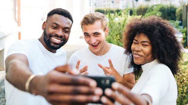 Verspielte Freunde im Freien nehmen Selfie