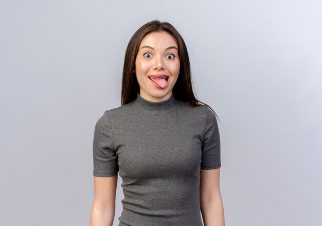Verspielte junge hübsche Frau, die Zunge lokalisiert auf weißem Hintergrund mit Kopienraum zeigt