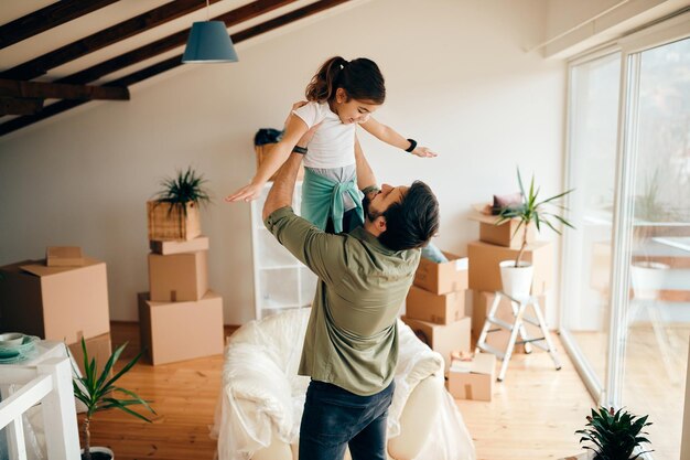 Verspielter Vater und Tochter haben Spaß in ihrem neuen Zuhause