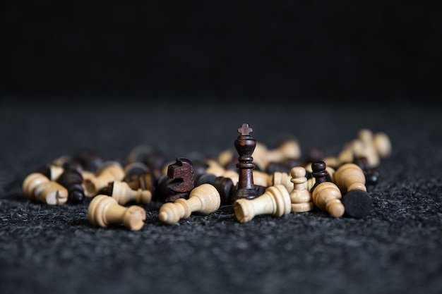 Verstreute Schachfiguren auf einem verschwommenen schwarzen Hintergrund