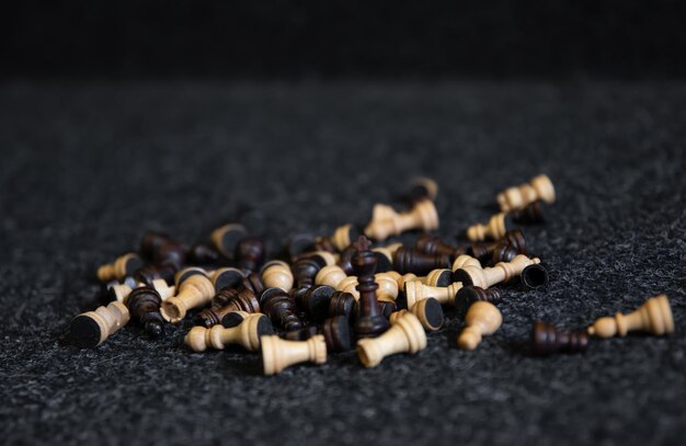 Verstreute Schachfiguren auf einem verschwommenen schwarzen Hintergrund