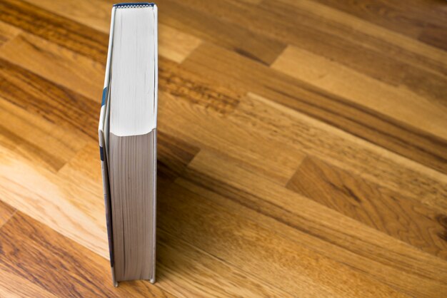 Vertikal Buch auf hölzerne Oberfläche