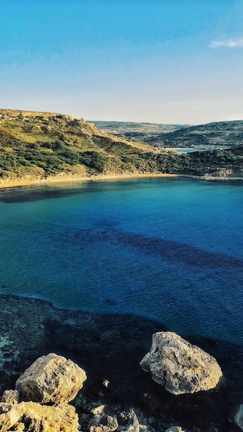 Vertikale Ansicht der atemberaubenden Ansicht des Golden Bay Beach in Mellieha Malta, die an einem sonnigen Tag eingefangen wird