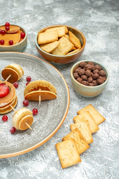 Vertikale Ansicht der hausgemachten Pfannkuchendekoration und der Kekse auf weißem Teller und Weiß
