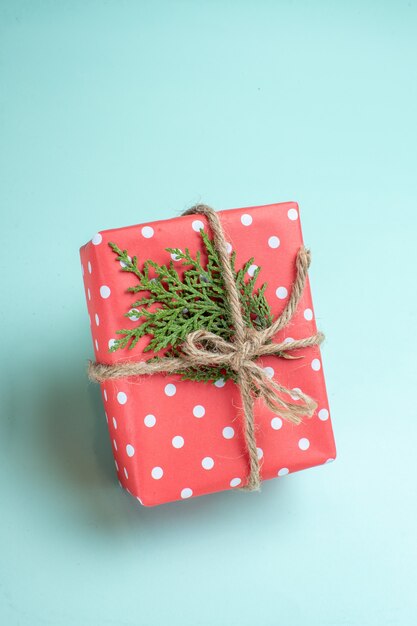 Vertikale Ansicht des Weihnachtshintergrundes mit Geschenkbox auf pastellgrünem Hintergrund