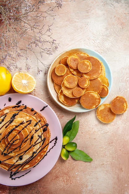 Vertikale Ansicht von einfachen und verzierten klassischen Pfannkuchenfrüchten auf buntem