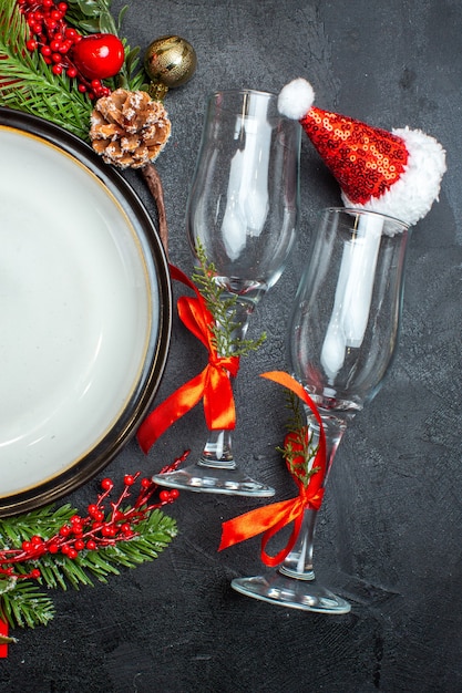 Vertikale Ansicht von Esstischdekorationszubehör Tannenzweigen Weihnachtssockenglasbecher auf dunklem Tisch