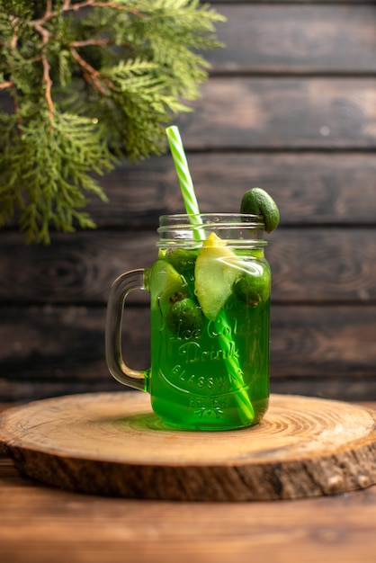 Vertikale Ansicht von frischem Saft mit Apfel und Feijoa auf einem Holztablett