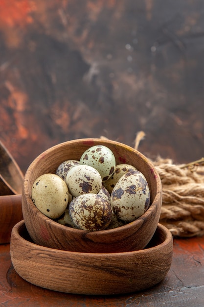 Vertikale Ansicht von frischen Eiern in einem Holztopf auf braunem Hintergrund