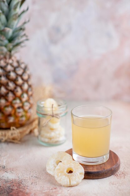 Vertikale Ansicht von frischer Grapefruit auf braunem Stoff und Fruchtsaft auf pastellfarbenem Hintergrund