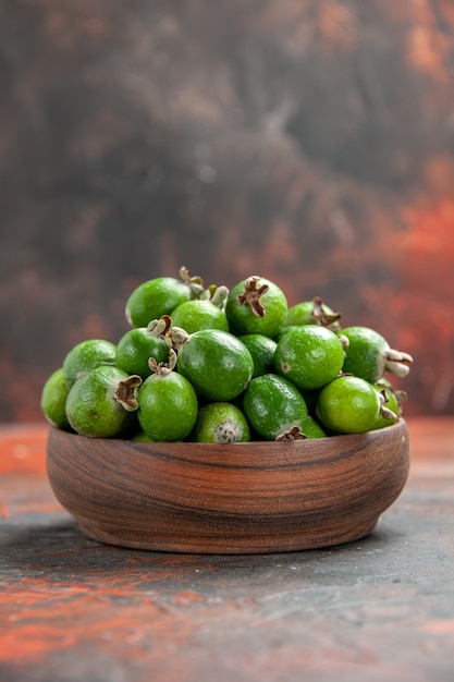 Kostenloses Foto vertikale ansicht von kleinen vitaminbombengrünen feijoas in einem braunen holztopf