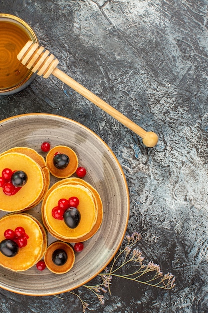 Vertikale Ansicht von leckeren Fruchtpfannkuchen und Honig