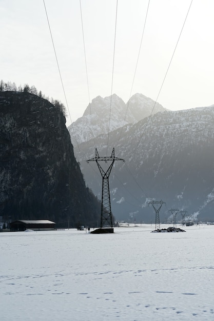 Vertikale Aufnahme der schneebedeckten Berge im Winter an einem nebligen Tag