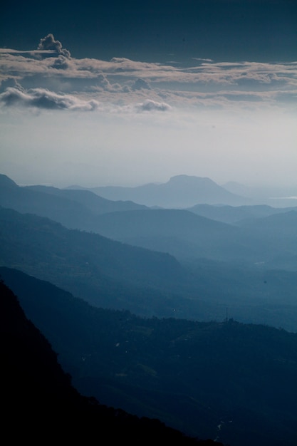 Vertikale Aufnahme der schönen Bergkette und des bewölkten Himmels am frühen Morgen