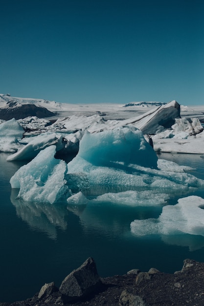 Vertikale Aufnahme der schönen Eisberge auf dem in Island gefangenen Wasser