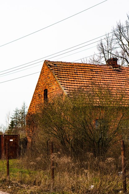 Vertikale Aufnahme des Backsteinhauses und eines Gartens daneben