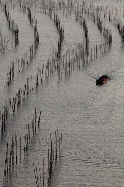 Kostenloses Foto vertikale aufnahme des fischerboots im ozean während des tages in xia pu, china