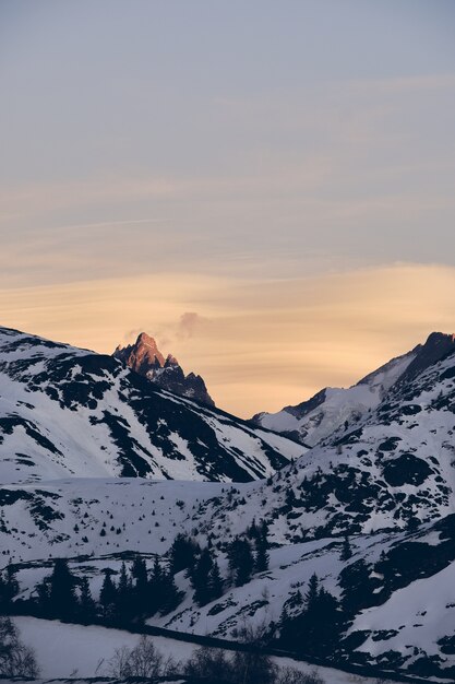 Vertikale Aufnahme des schönen schneebedeckten Alpenberges