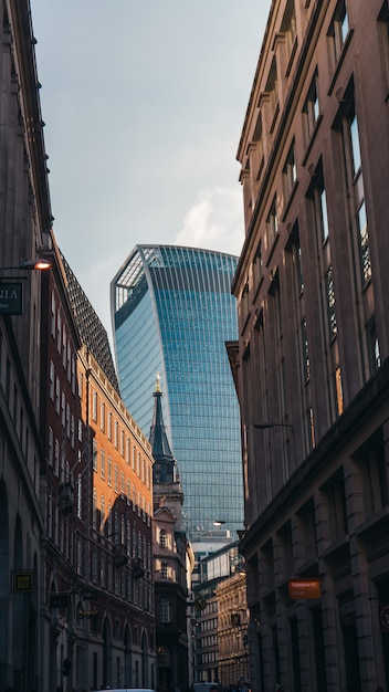 Vertikale Aufnahme des Walkie Talkie Tower zwischen Gebäuden in London, England