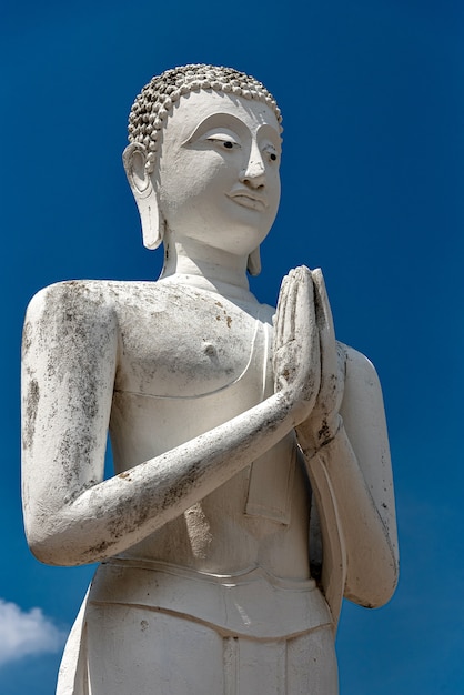 Vertikale Aufnahme einer alten Buddha-Statue mit einem klaren blauen Himmel