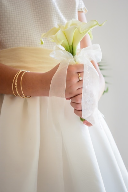 Vertikale Aufnahme einer Braut mit einem schönen Brautstrauß mit weißen Blumen