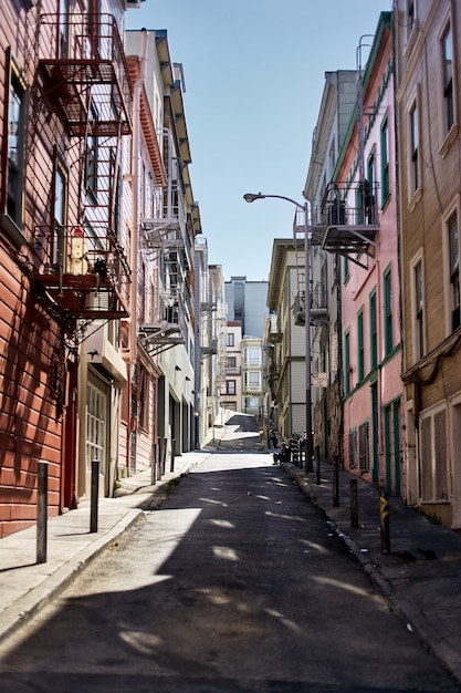Vertikale Aufnahme einer Gasse zwischen Mehrfamilienhäusern in San Francisco, Kalifornien an einem sonnigen Tag