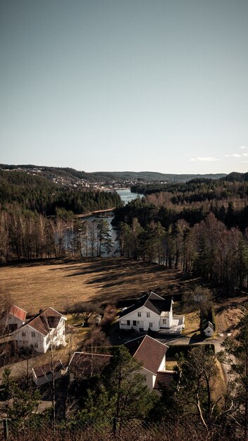 Vertikale Aufnahme einer schönen Ansicht von Häusern und Bäumen nahe dem Fluss