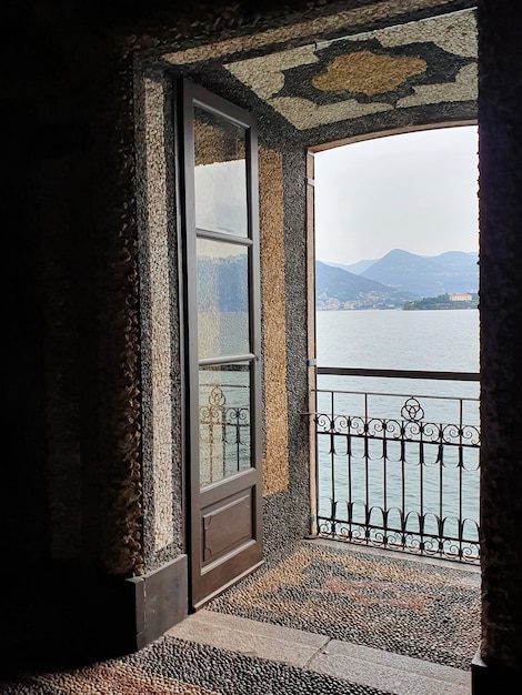 Vertikale Aufnahme eines Balkons mit Blick auf das Meer und die Hügel