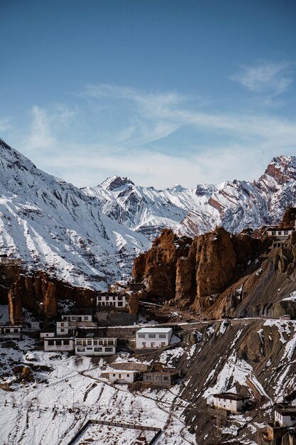 Vertikale Aufnahme eines Dhankar-Klosters im Spiti-Tal mit schneebedeckten Bergen in der