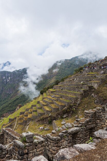 Vertikale Aufnahme eines faszinierenden Machu Pichu-Berges an einem nebligen Tag
